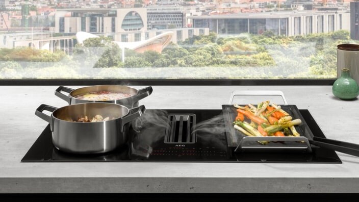 Inductiekookplaat met afzuiging in een keuken met uitzicht op de stad