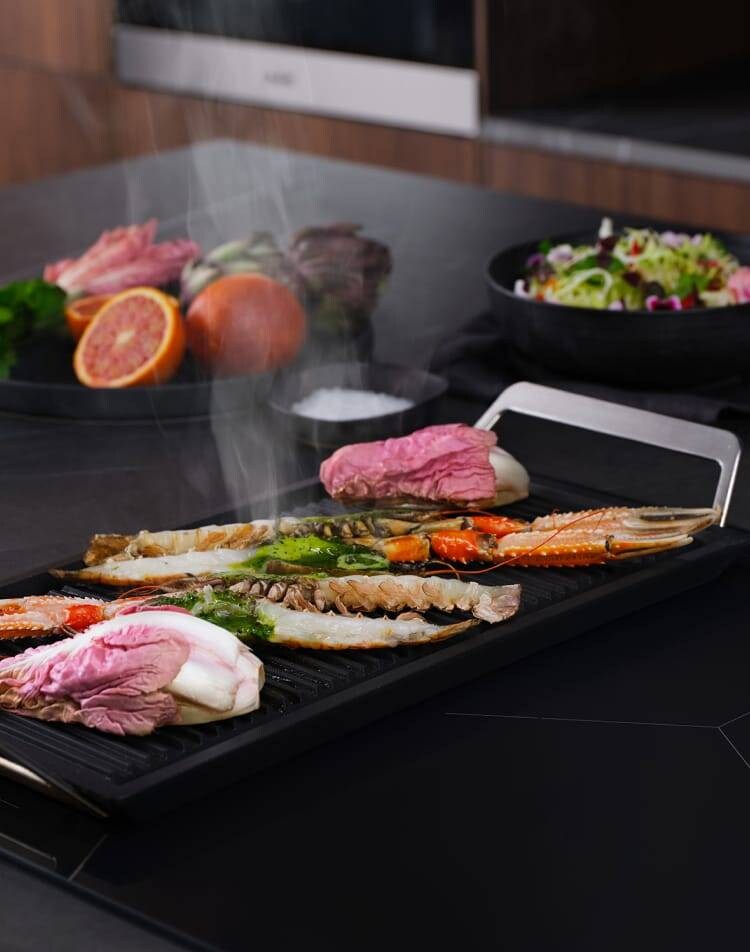 Différents types d’aliments sont préparés sur une taque de cuisson à induction dotée de la fonction FlexBridge.