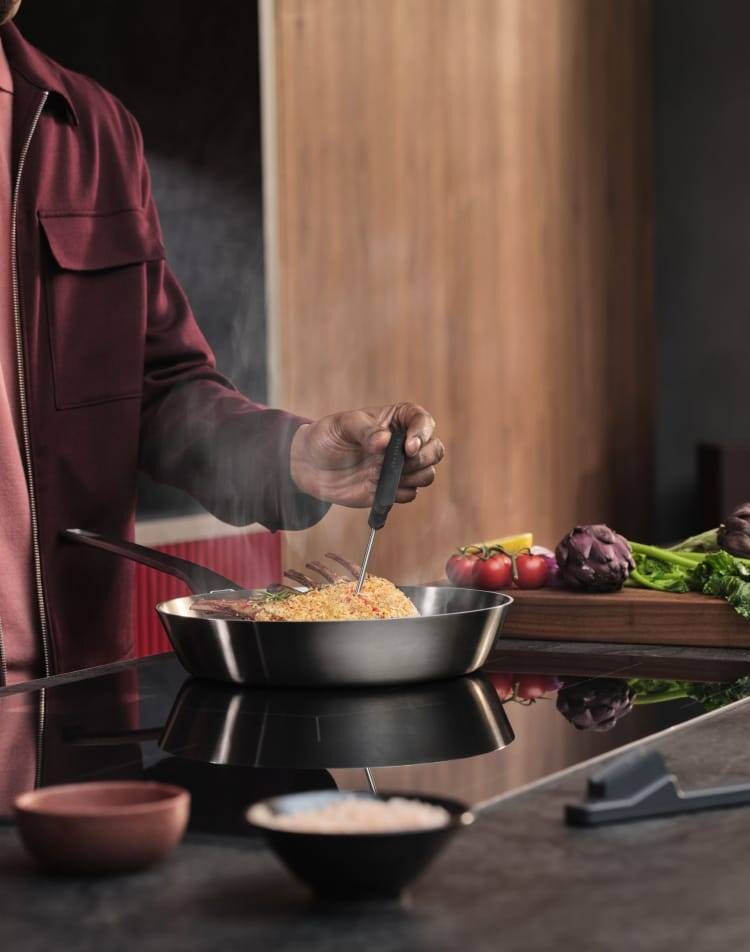 Une personne prépare des aliments sur une taque de cuisson à induction.