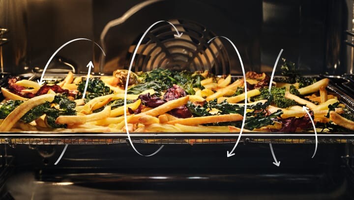 Patat en groenten worden bereid in een oven.