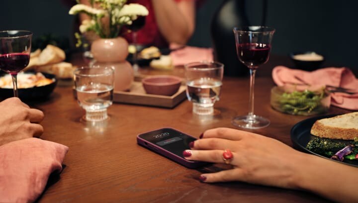 Mensen rond een tafel met eten en drinken. 
