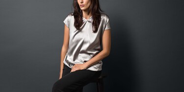 Vrouw in een net gewassen zilverkleurige, zijden blouse