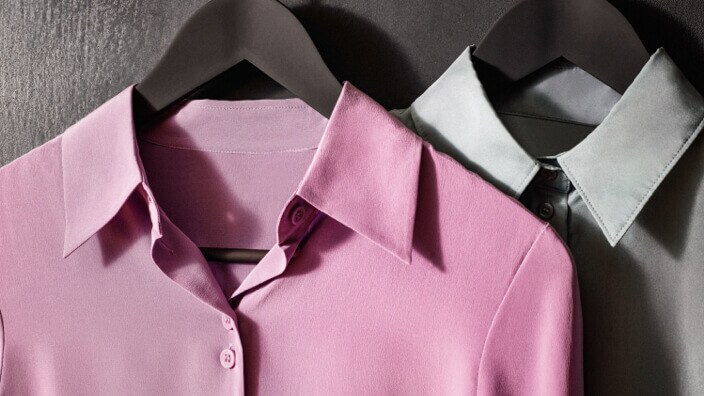Roze en grijze hemden op kleerhangers