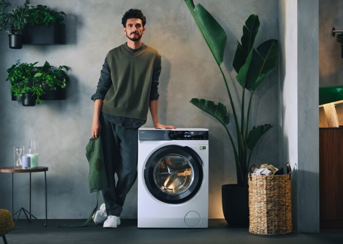 homme à côté d'une machine à laver AEG