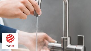 Un homme touche le bec verseur en toute sécurité pour se servir en l'eau bouillante.