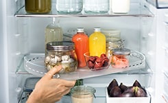 Hand taking out tray from fridge