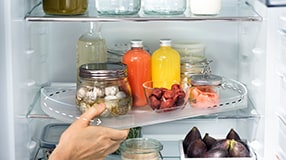 Hand taking out tray from fridge