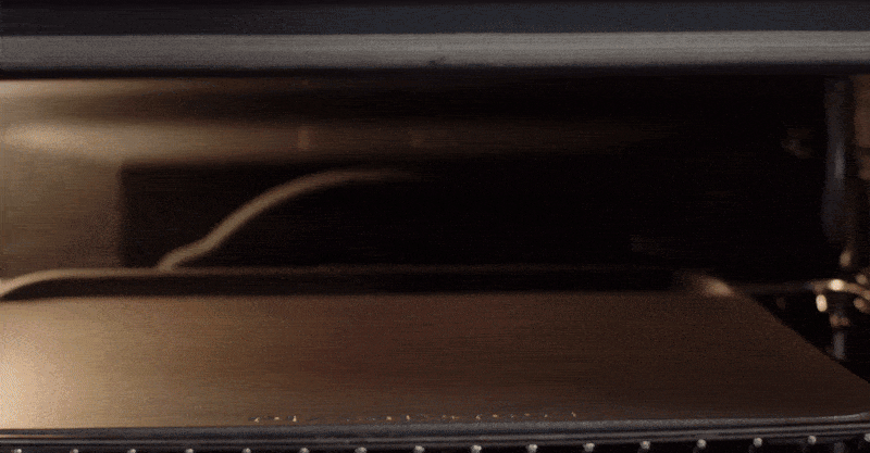 Video van een persoon die pizza maakt met behulp van een oven
