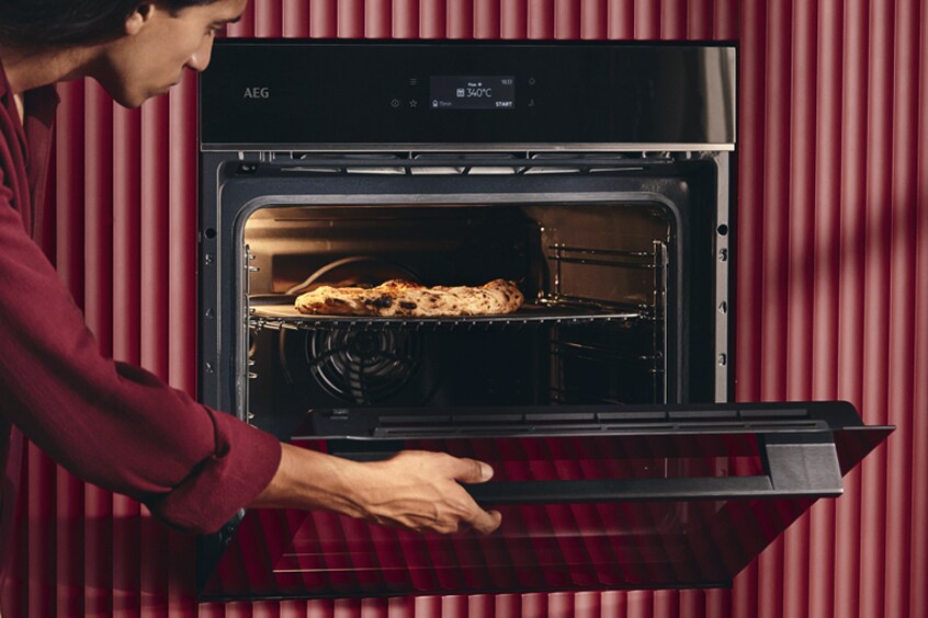 Vrouw die de ovendeur opent