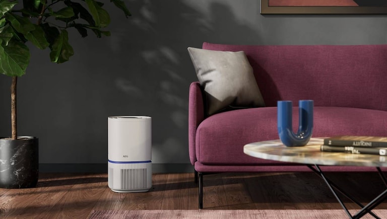 Luchtreiniger naast een zetel in een woonkamer