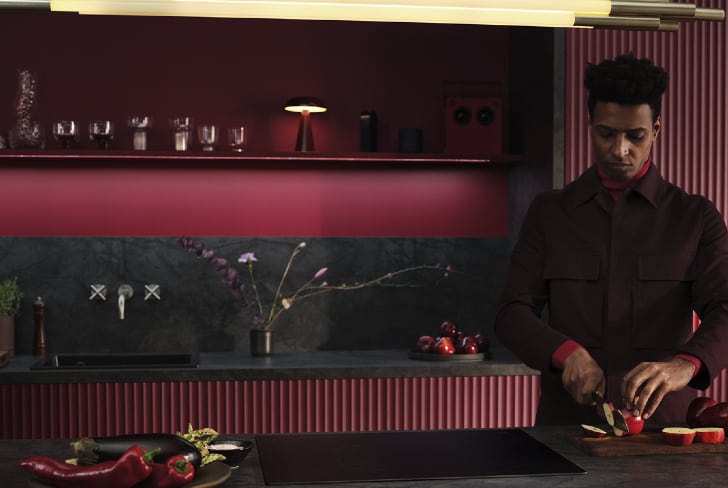 Un homme en train de couper des fruits dans une cuisine.