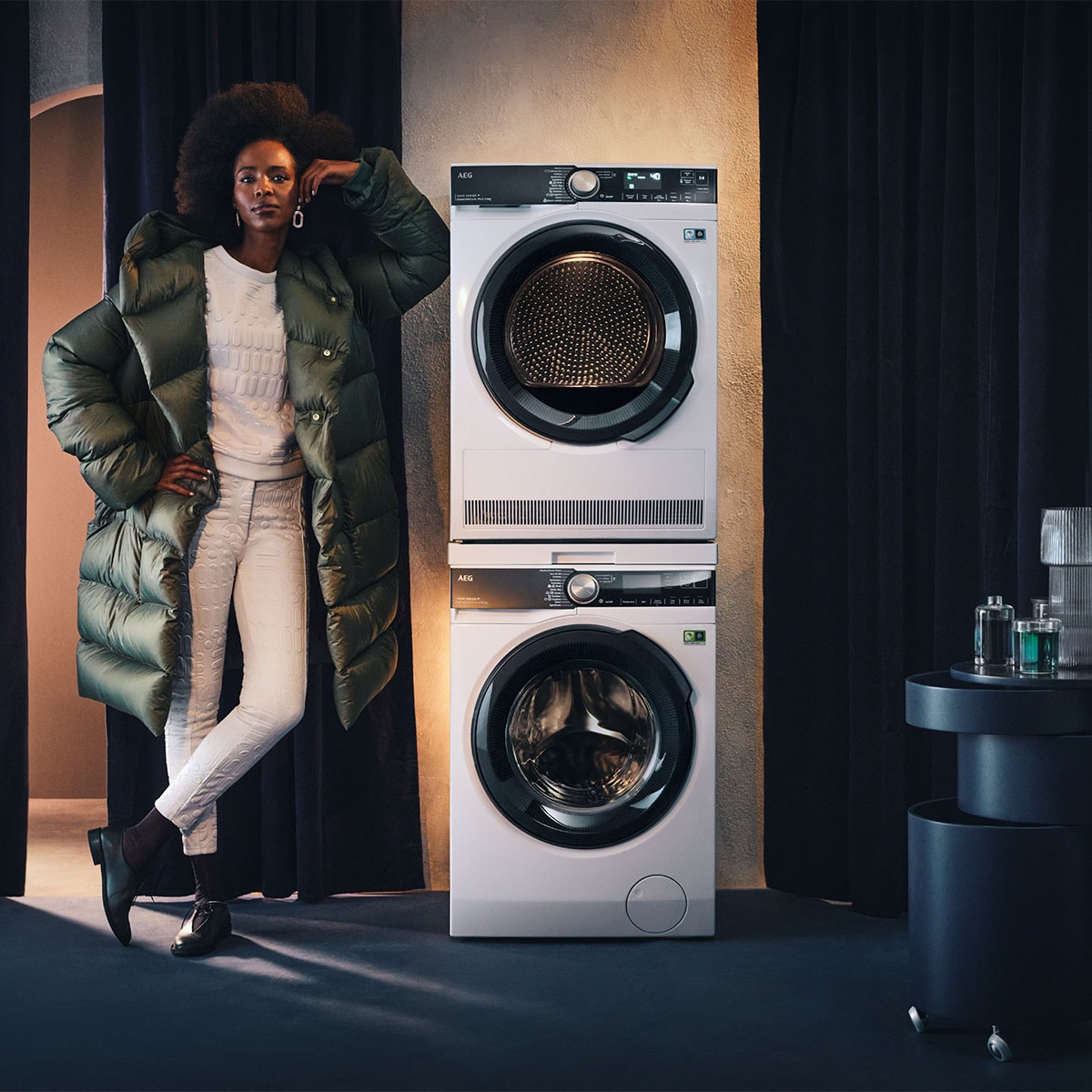 vrouw staat naast AEG wasmachine en droogkast