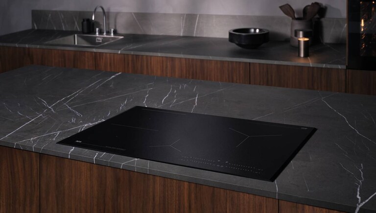 Cuisson d’aliments dans une casserole placée sur une plaque AEG.